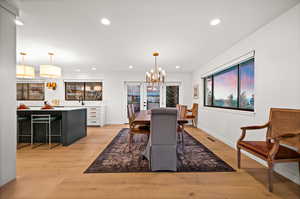 Dining room with a notable chandelier and light hardwood / wood-style floors