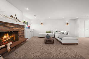 Carpeted living room featuring a stone fireplace