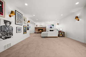 Living room featuring light carpet and a stone fireplace