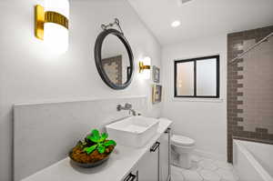 Full bathroom with tiled shower / bath, vanity, toilet, and tile patterned flooring