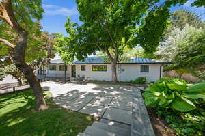 Ranch-style home featuring a front lawn and a patio