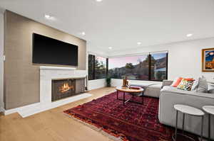 Living room with a fireplace and hardwood / wood-style flooring