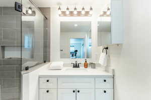 Bathroom featuring vanity and a shower with shower door