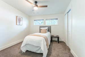 Carpeted bedroom with a closet and ceiling fan