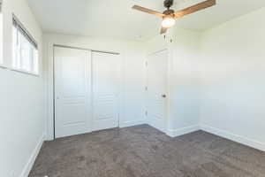 Unfurnished bedroom featuring carpet, a closet, and ceiling fan