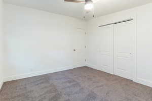 Unfurnished bedroom with carpet flooring, a closet, and ceiling fan