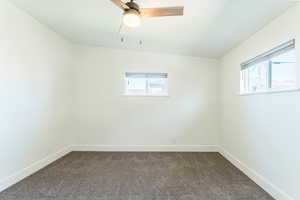 Carpeted empty room with ceiling fan