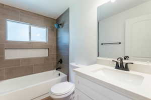 Full bathroom featuring vanity, toilet, and tiled shower / bath