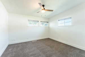 Empty room with ceiling fan and carpet floors