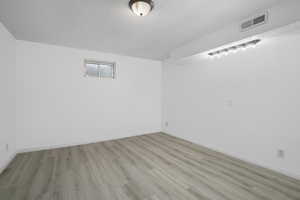 basement's 3rd bedroom with light vinyl wood type flooring and a textured ceiling