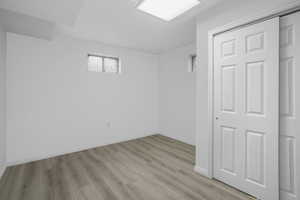 Basement bedroom featuring light vinyl wood flooring