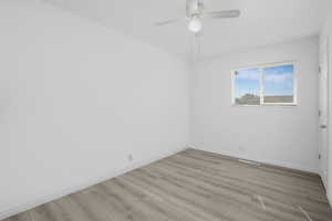 Downstair's bedroom featuring ceiling fan and light vinyl wood-type flooring