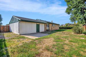 Rear view of property featuring a yard and a patio