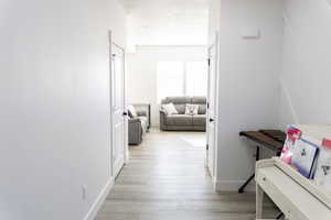 Hallway with light hardwood / wood-style flooring