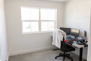 Home office with a healthy amount of sunlight and carpet flooring