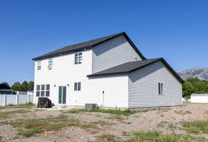 Back of house featuring a mountain view, central AC, and a patio