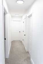 Hall featuring light colored carpet