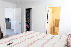 Carpeted bedroom featuring ensuite bath and a closet