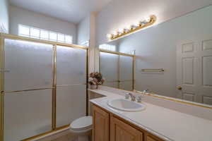 Bathroom with vanity, toilet, and an enclosed shower