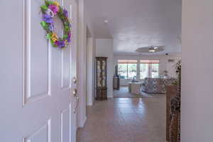 Entryway featuring tile patterned flooring and ceiling fan