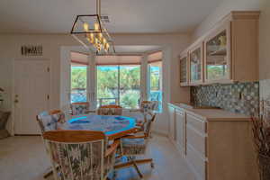 Dining space with a notable chandelier and light tile patterned flooring