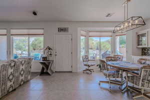 Dining area with a healthy amount of sunlight, a chandelier, and light tile patterned flooring