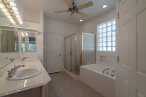 Bathroom with shower with separate bathtub, ceiling fan, vanity, and tile patterned floors