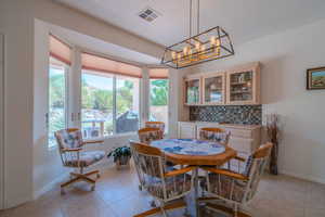 Dining space featuring an inviting chandelier and light tile patterned flooring