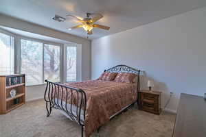 Carpeted bedroom with ceiling fan