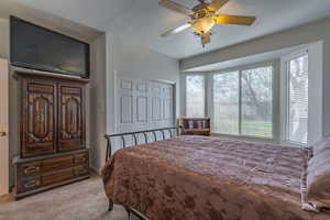 Carpeted bedroom with a closet and ceiling fan