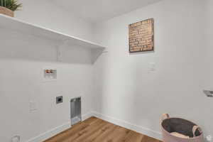 Clothes washing area with washer hookup, hardwood / wood-style floors, and hookup for an electric dryer