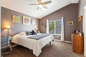 Bedroom featuring vaulted ceiling, ceiling fan, and carpet flooring