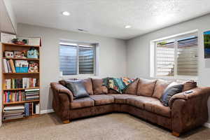 Living room with a textured ceiling and carpet