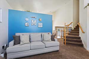 Living room with carpet flooring and high vaulted ceiling