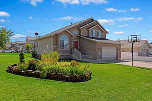 Front of property featuring a garage and a front lawn