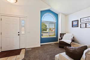 Tiled foyer entrance featuring lofted ceiling