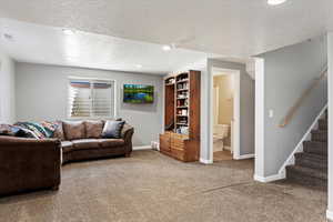 Carpeted living room featuring a textured ceiling