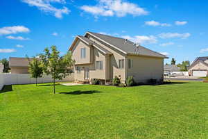 Rear view of property with a lawn and a garage