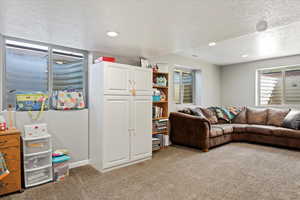 Living room with a textured ceiling and light colored carpet