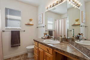 Bathroom with vanity, toilet, and tile patterned flooring