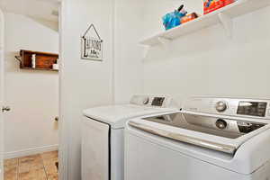 Laundry area with light tile patterned floors and washer and clothes dryer