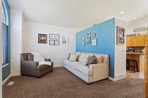 Living room with vaulted ceiling and light carpet