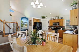 Dining space featuring lofted ceiling, light tile patterned flooring, a notable chandelier, and sink