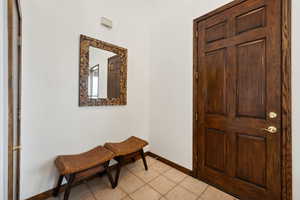 Foyer entrance featuring light tile patterned floors