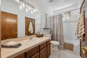 Full bathroom with tile patterned flooring, vanity, toilet, and shower / tub combo