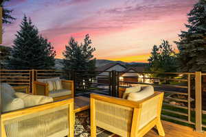 Deck at dusk with an outdoor living space and a mountain view