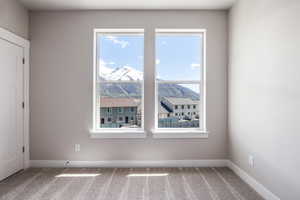 Spare room featuring carpet flooring and a mountain view