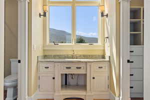 Bathroom featuring toilet, a mountain view, and vanity