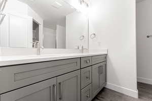 Bathroom featuring hardwood / wood-style flooring, vanity, an enclosed shower, and a textured ceiling