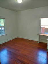 Unfurnished room featuring a textured ceiling and dark hardwood / wood-style floors